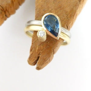 White and yellow gold and cornflower blue pear shape sapphire ring. Multi band ring or interlocking ring, sometimes called double band ring too.
