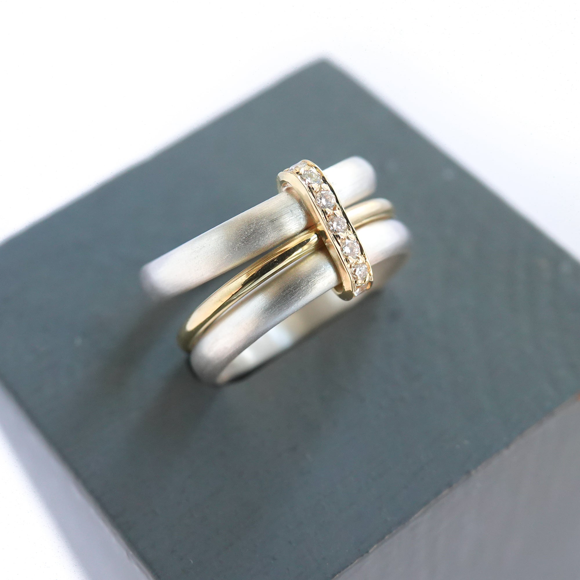 Contemporary treble band looped 18ct gold and diamond ring. Multi banded.