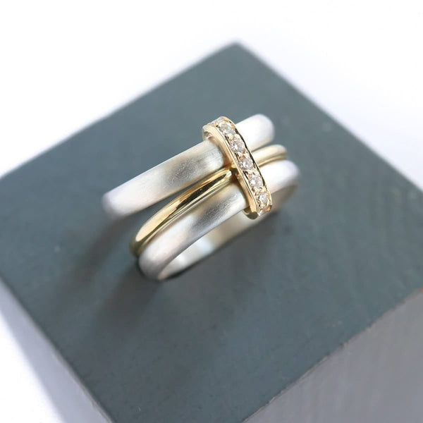 Contemporary treble band looped 18ct gold and diamond ring. Multi banded.