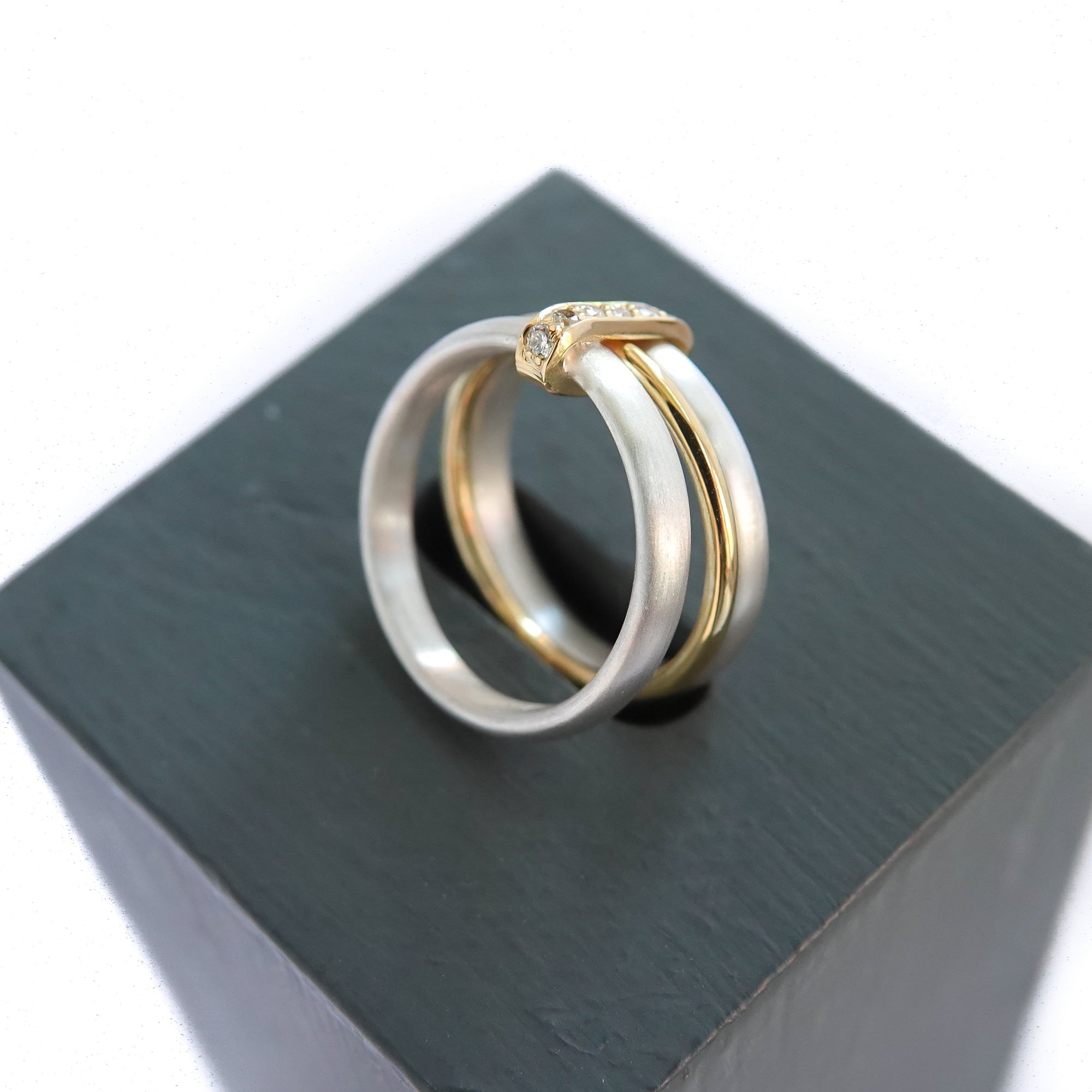 Contemporary treble band looped 18ct gold and diamond ring. Multi banded.
