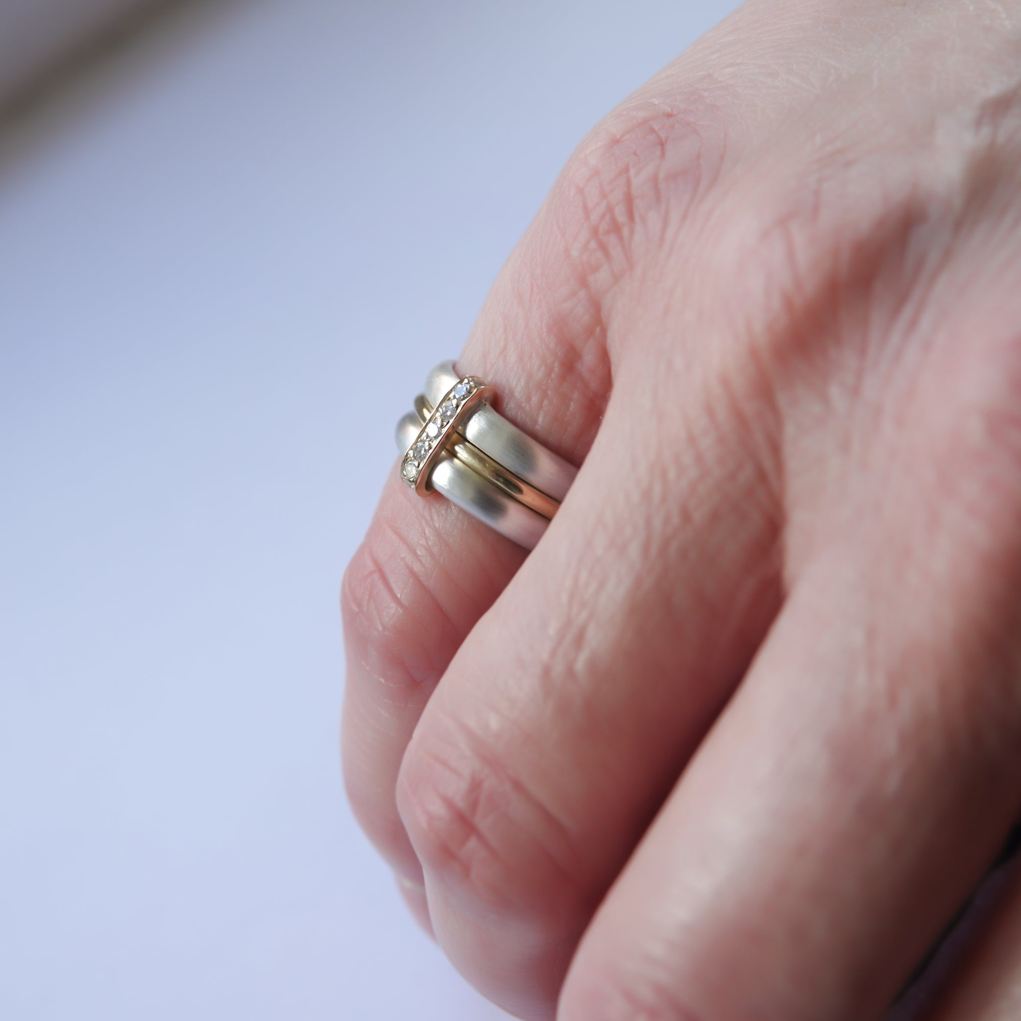 Contemporary treble band looped 18ct gold and diamond ring. Multi banded.