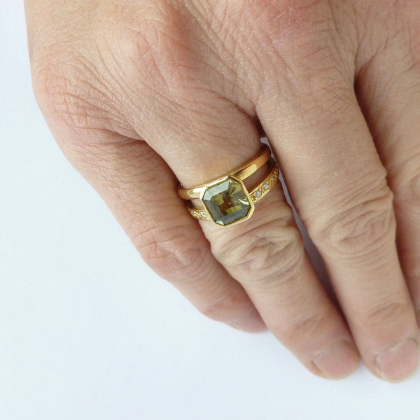 Unusual olive‑green sapphire ring with diamond set band