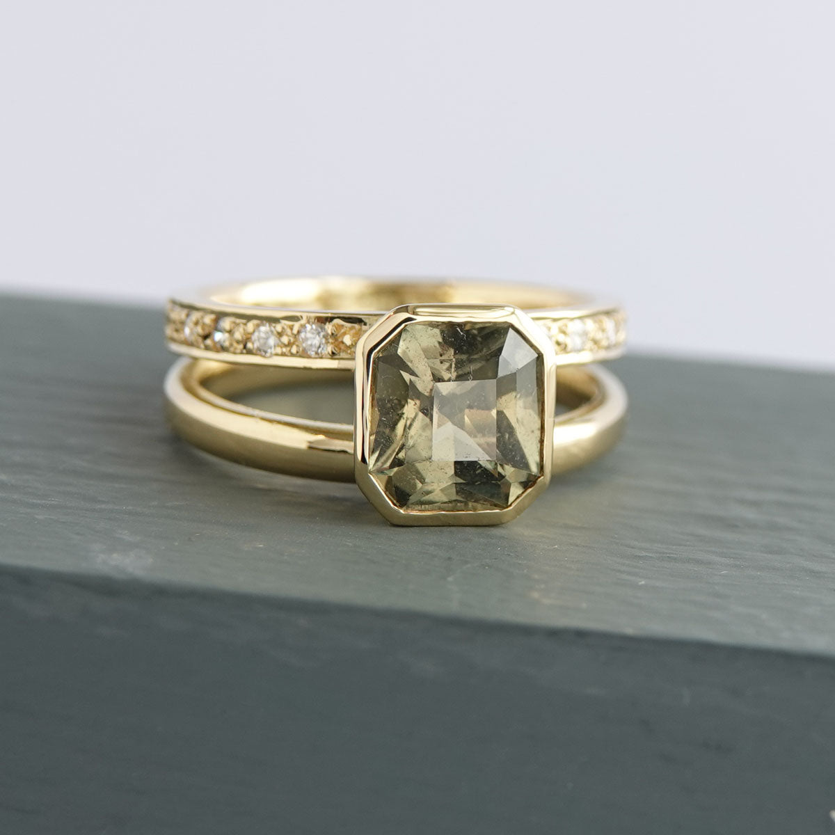 Unique olive green sapphire engagement ring with sculptural double band in yellow gold