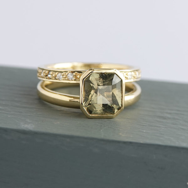 Unique olive green sapphire engagement ring with sculptural double band in yellow gold