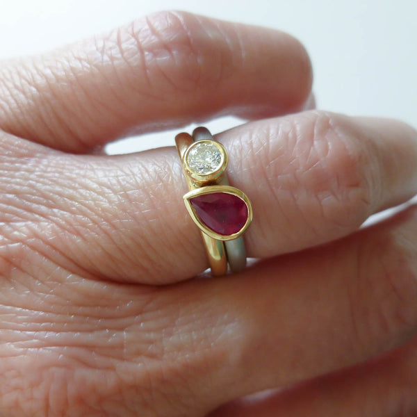 Ruby anniversary present idea: Model wearing a contemporary ruby wedding and engagement ring set.