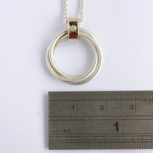 Detail of contemporary Russian ring pendant with interlocking silver rings and gold loop