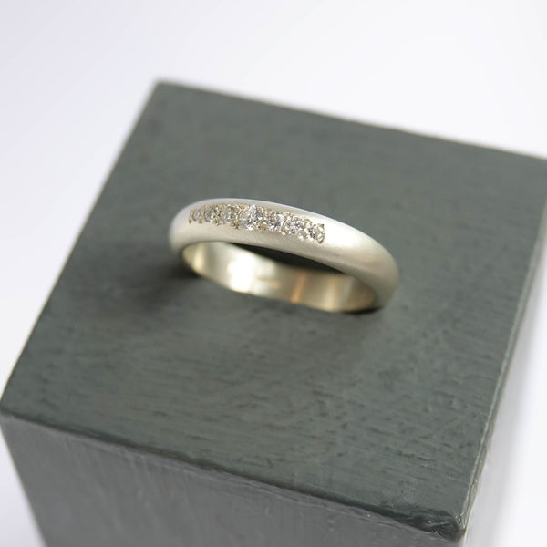 Modern engagement ring in 9ct white gold with an organic row of 7 sparkling diamonds.