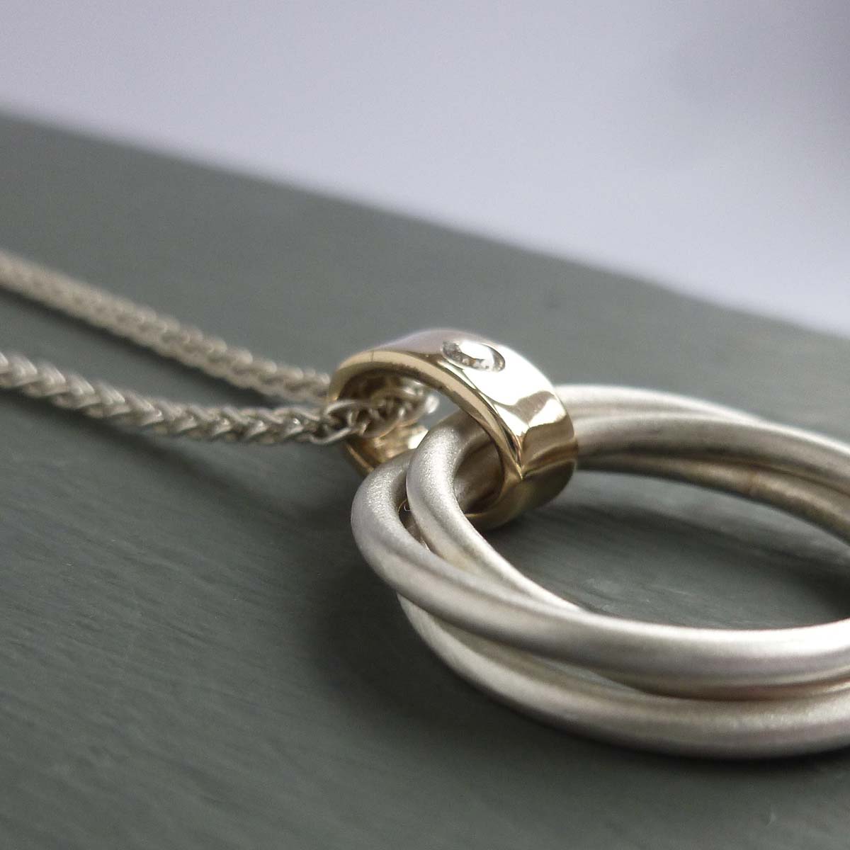 modern two tone silver and gold multi band circle pendant handmade in England 