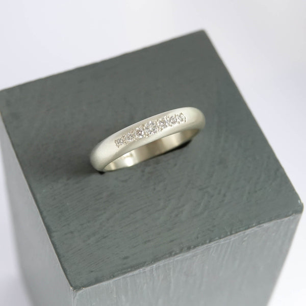Detail of 7 ethically sourced pavé diamonds organically set in a 9ct white gold band.