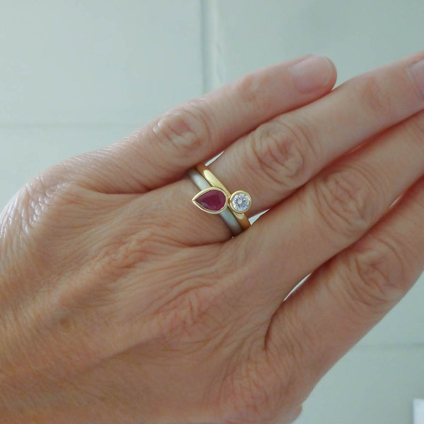 Model wearing a luxury stacked engagement ring and ruby wedding band set.