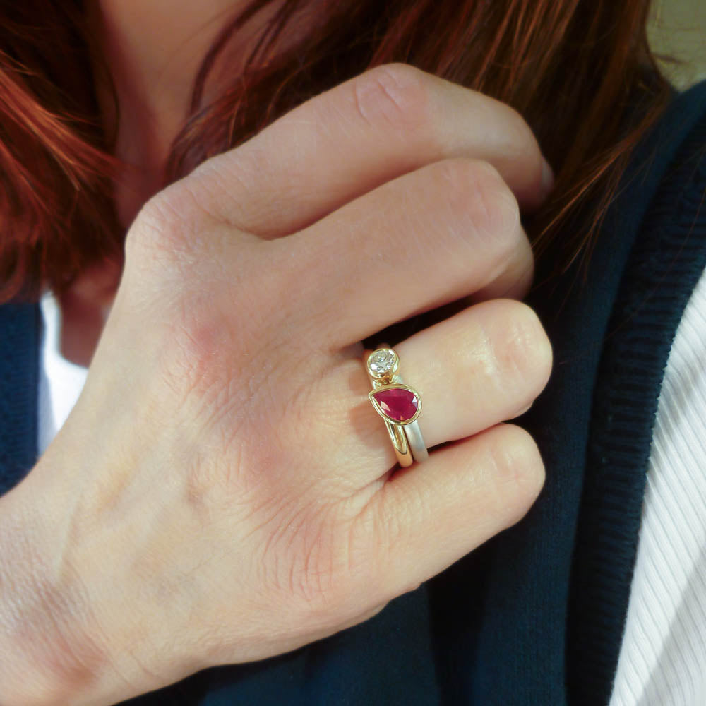 Ruby anniversary present idea: Model wearing a contemporary ruby wedding and engagement ring set.