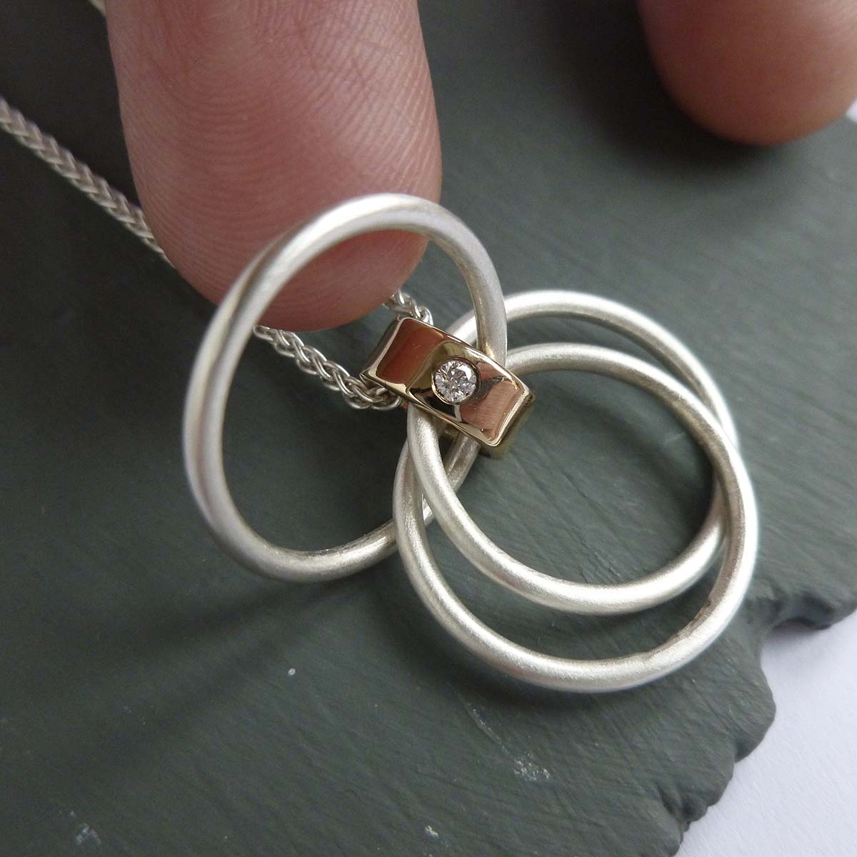 modern two tone silver and gold multi band circle pendant handmade in England 
