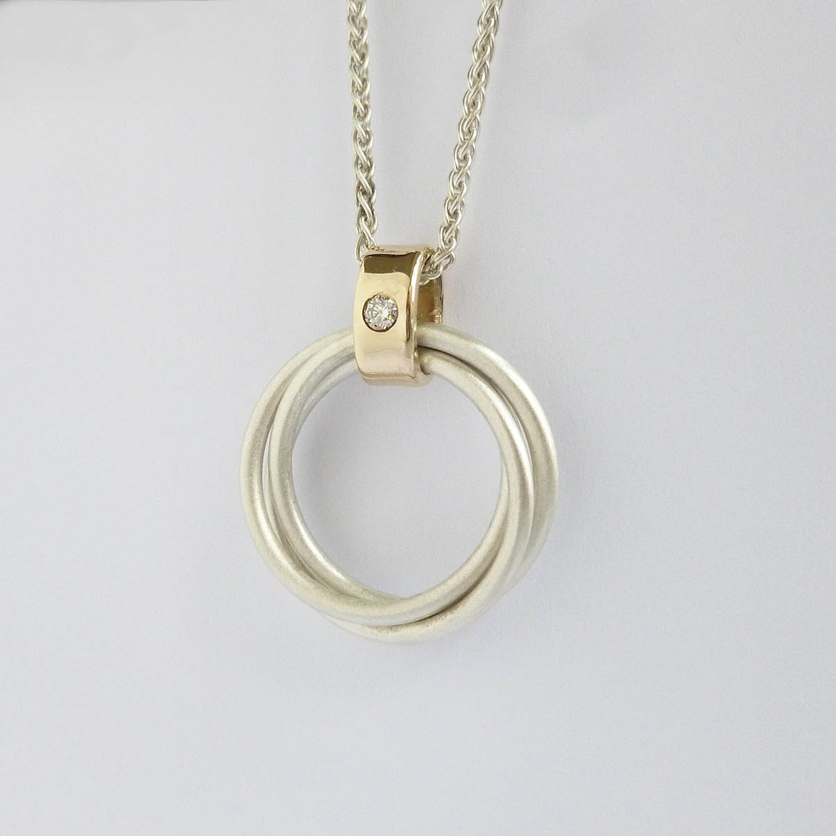 modern two tone silver and gold multi band circle pendant handmade in England 