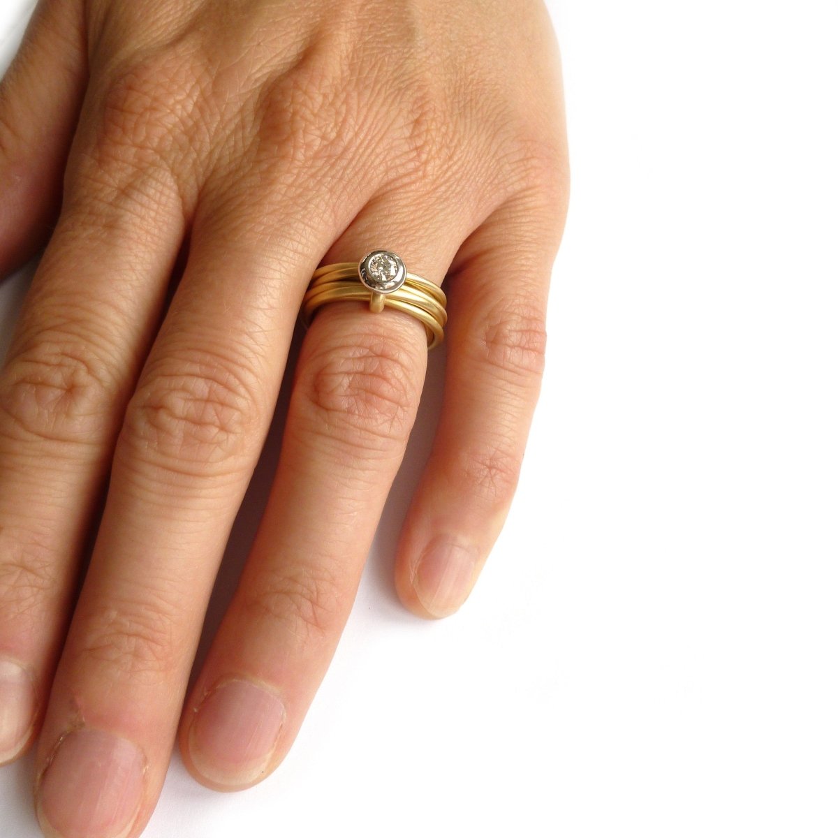 Contemporary, bespoke and modern yellow gold multi band engagement wedding ring, 0.25pt round white diamond, handmade by designer maker sue lane jewellery. Multi band ring or interlocking ring.