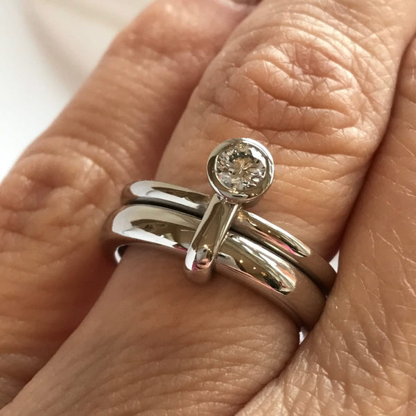 modern contemporar platinum two band stacking ring wih round white diamond. A unique one of a kind design by Sue Lane. Multi band ring or interlocking ring, sometimes called double band ring too.