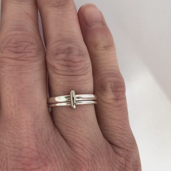 Handmade silver spinner ring with a gold loop on a contemporary double band design.