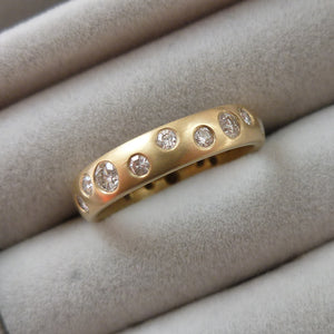 A modern unique eternity ring with 20 diamonds. Beautiful contemporary wedding, eternity or engagement ring.