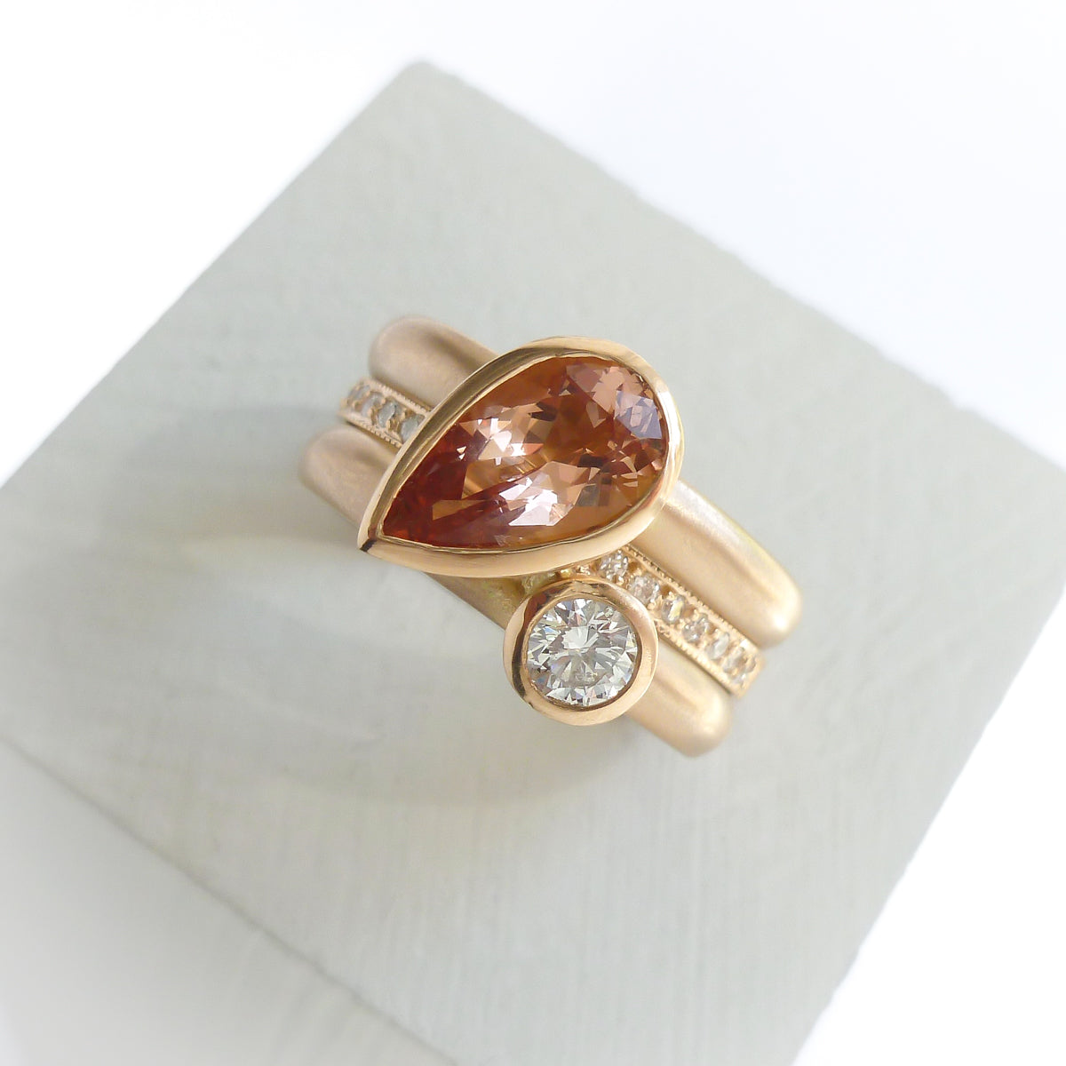 Contemporary rose gold and pear shaped imperial topaz stacking interlocking ring set.