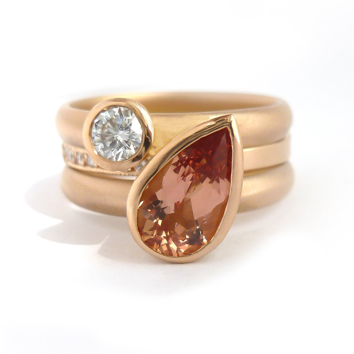 Contemporary rose gold and pear shaped imperial topaz stacking interlocking ring set.