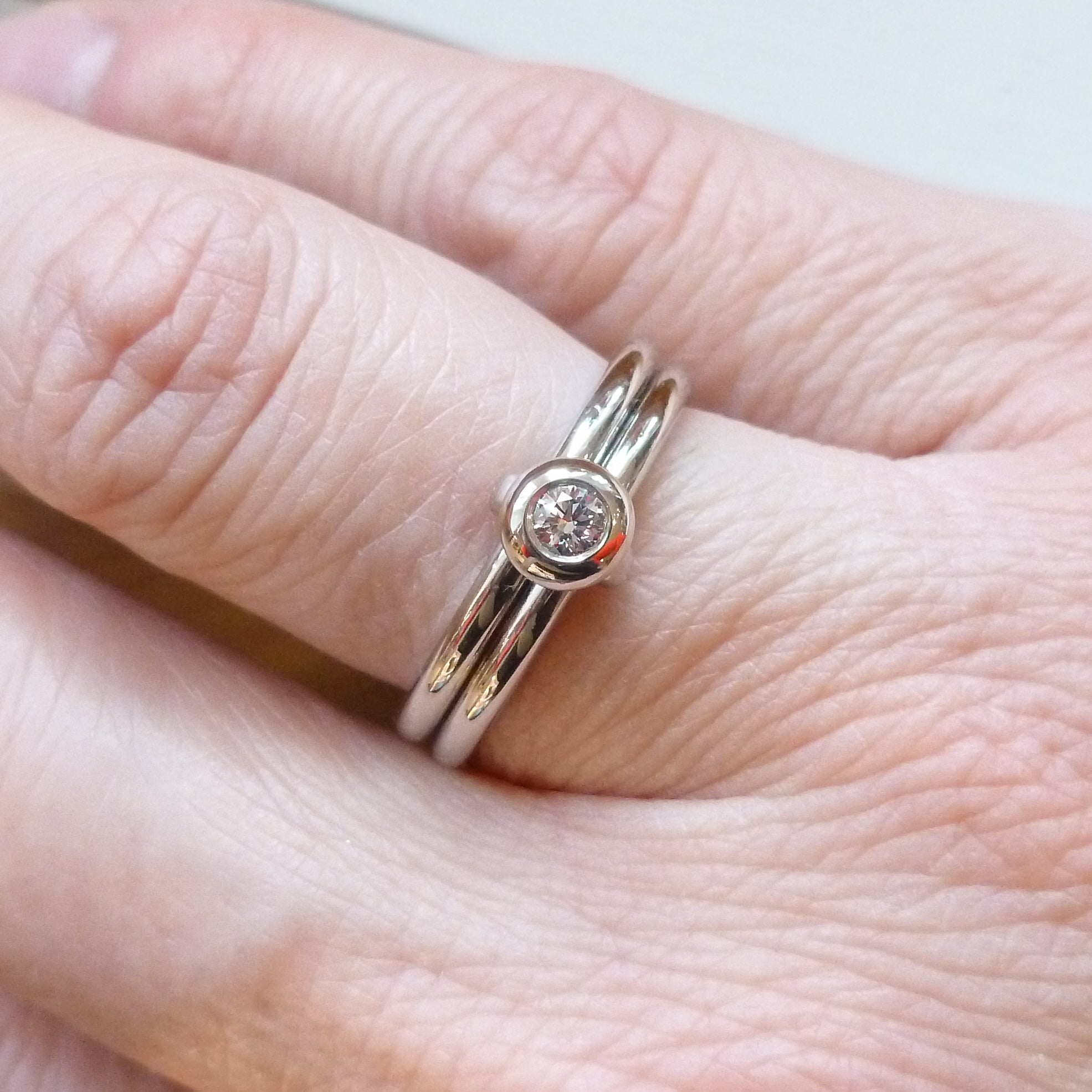 Contemporary platinum two band engagement ring with diamond. Bespoke. Multi band ring or interlocking ring, sometimes called double band ring too.