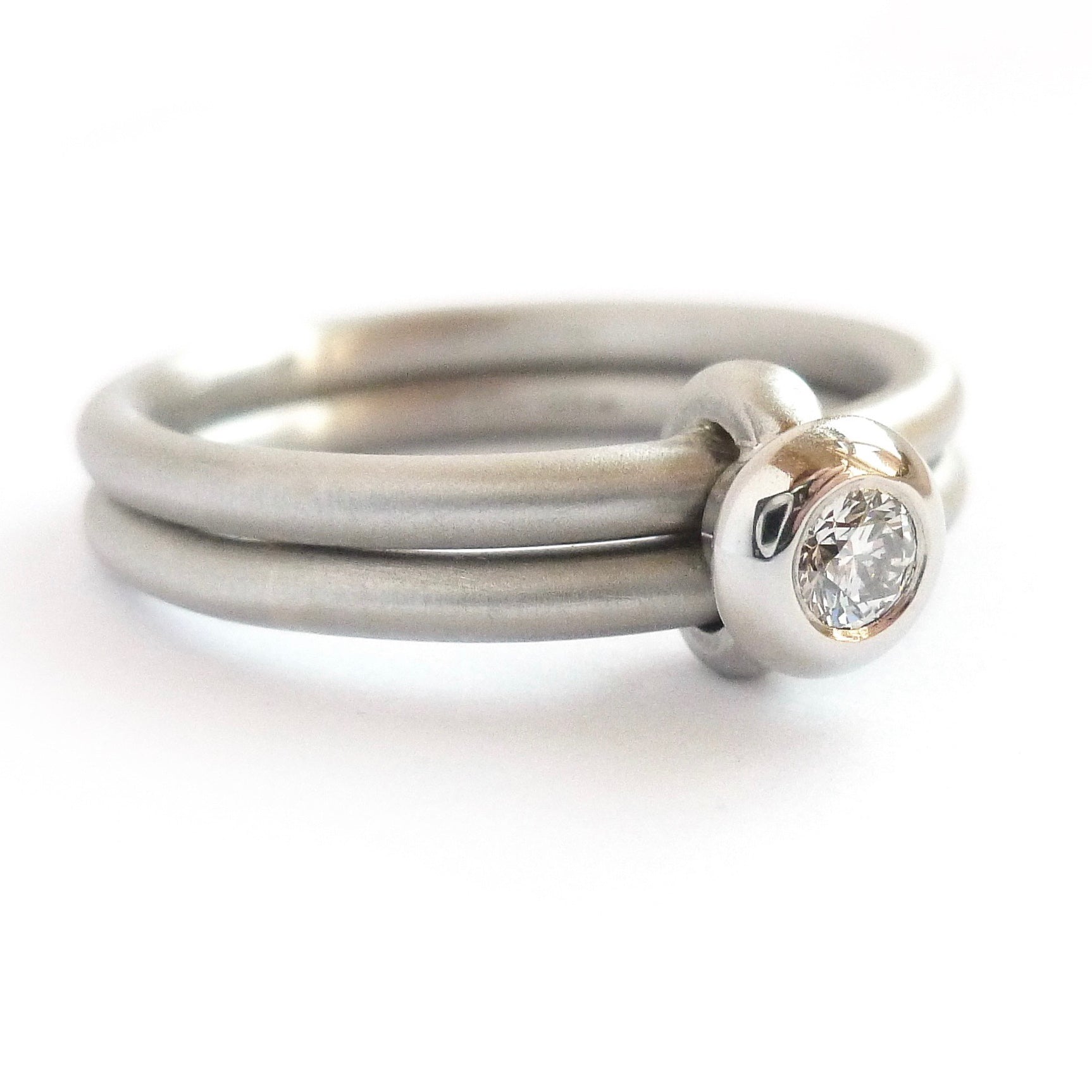 Contemporary platinum two band engagement ring with diamond. Bespoke. Multi band ring or interlocking ring, sometimes called double band ring too.