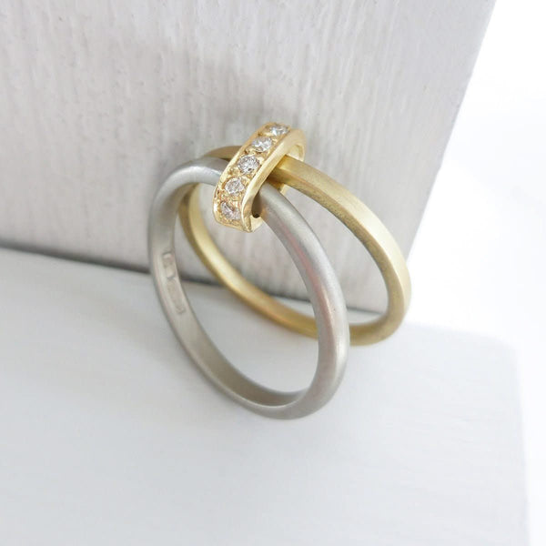 Modern and bespoke two band two tone ring with pave set diamonds. Modern, unique two band ring joined together with diamonds. An alternative eternity or wedding ring. Multi band ring or interlocking ring, sometimes called double band ring too.