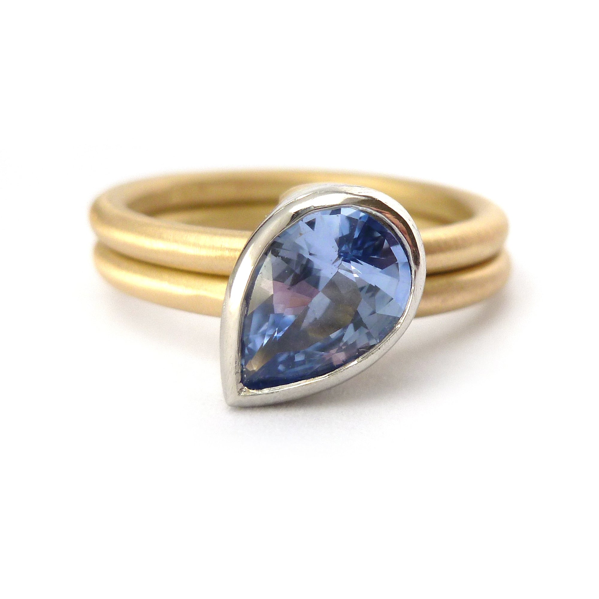 Unique, bespoke and modern statement platinum and gold and pear shape cornflower blue sapphire stacking ring set handmade by designer maker Sue Lane Jewellery