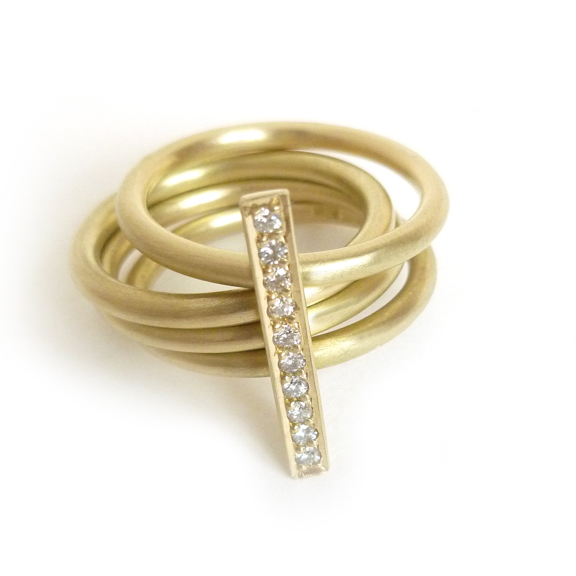 A contemporary heavy weight modern four band stacking gold ring with a row of pave diamonds. Multi band ring or interlocking ring.