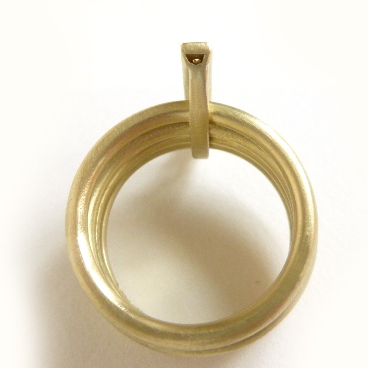 A contemporary chunky modern four band stacking gold ring with a row of pave diamonds. Multi band ring or interlocking ring.