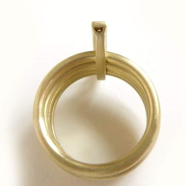 A contemporary chunky modern four band stacking gold ring with a row of pave diamonds. Multi band ring or interlocking ring.