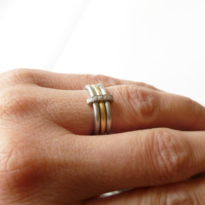 Modern two tone, platinum and yellow gold three band eternity ring with diamonds. Multi band ring or interlocking ring, sometimes called triple band rings too.