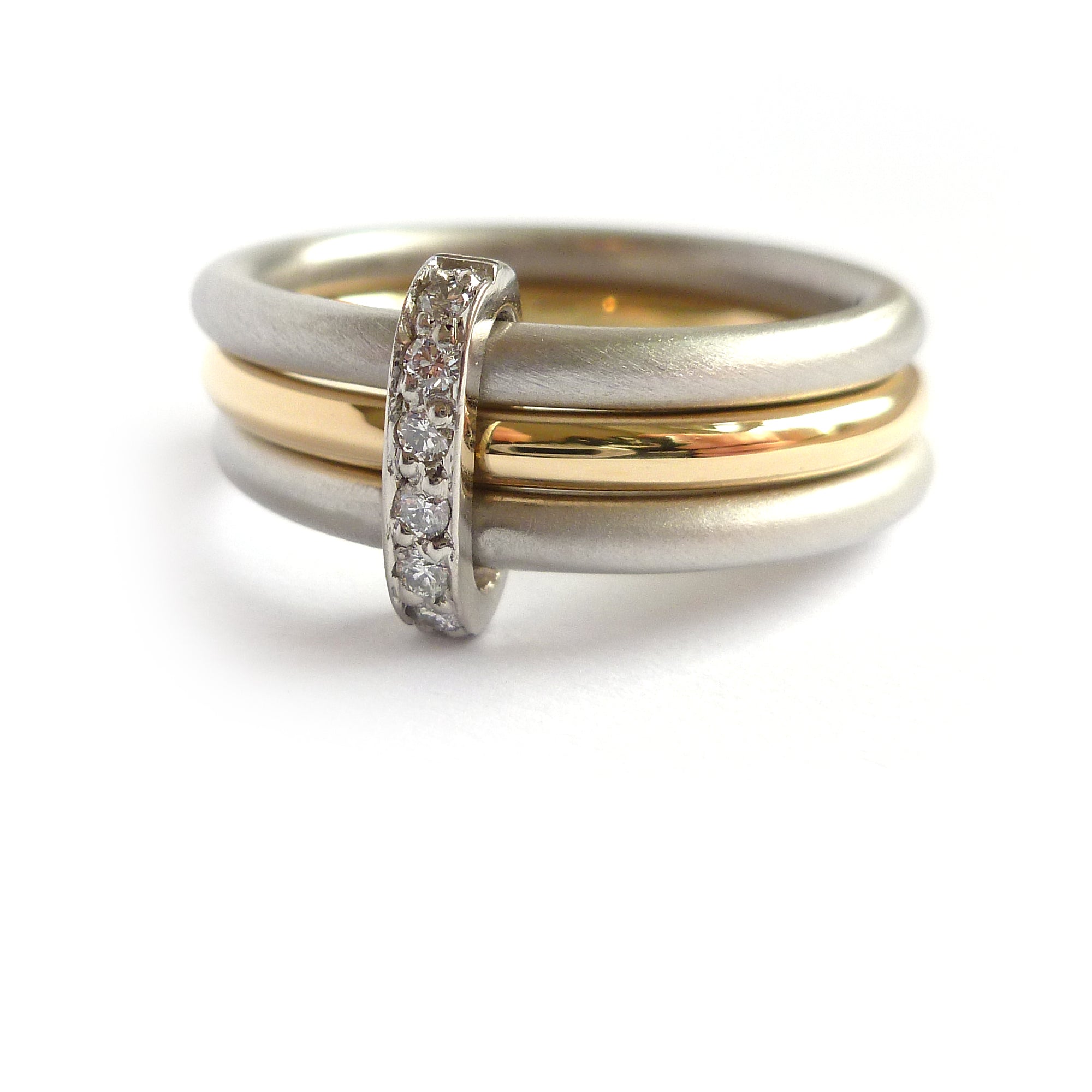 Contemporary two tone, platinum and yellow gold three band stacking ring with diamonds. Multi band ring or interlocking ring, sometimes called triple band rings too.
