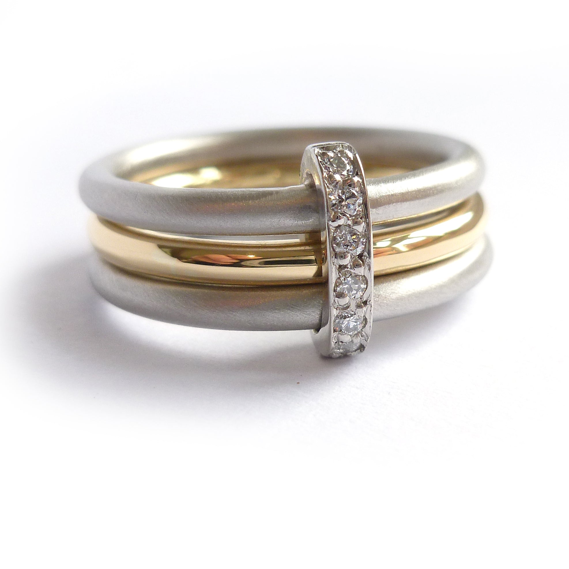 Modern platinum and gold two tone, white and yellow three band ring with diamonds. Multi band ring or interlocking ring, sometimes called triple band rings too.