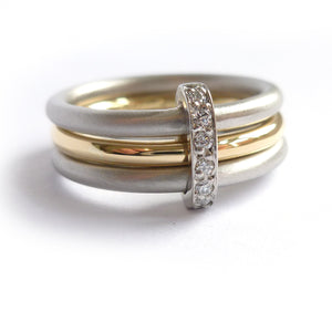 Modern platinum and gold two tone, white and yellow three band ring with diamonds. Multi band ring or interlocking ring, sometimes called triple band rings too.