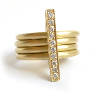 A heavy weight modern four band stacking gold ring with a row of pave diamonds. Multi band ring or interlocking ring.