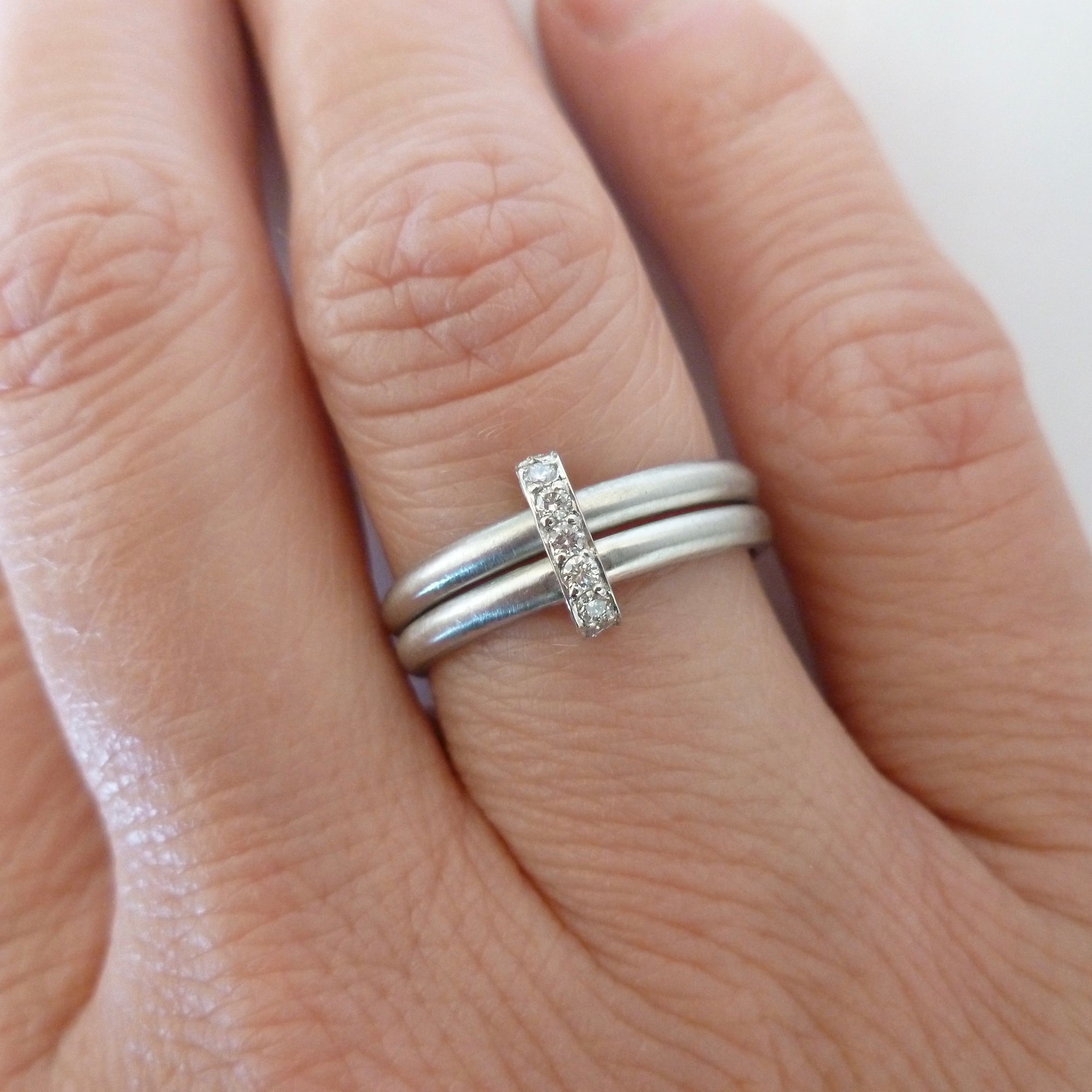 Contemporary modern platinum and diamond eternity ring or wedding ring. Multi band ring or interlocking ring, sometimes called double band ring too.