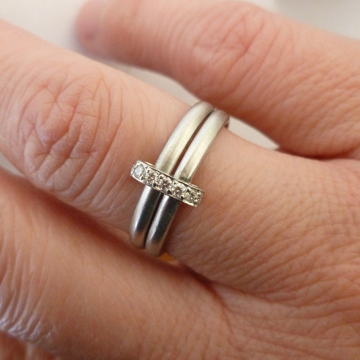 Contemporary two band platinum stacking ring with pave set diamonds. Multi band ring or interlocking ring, sometimes called double band ring too.