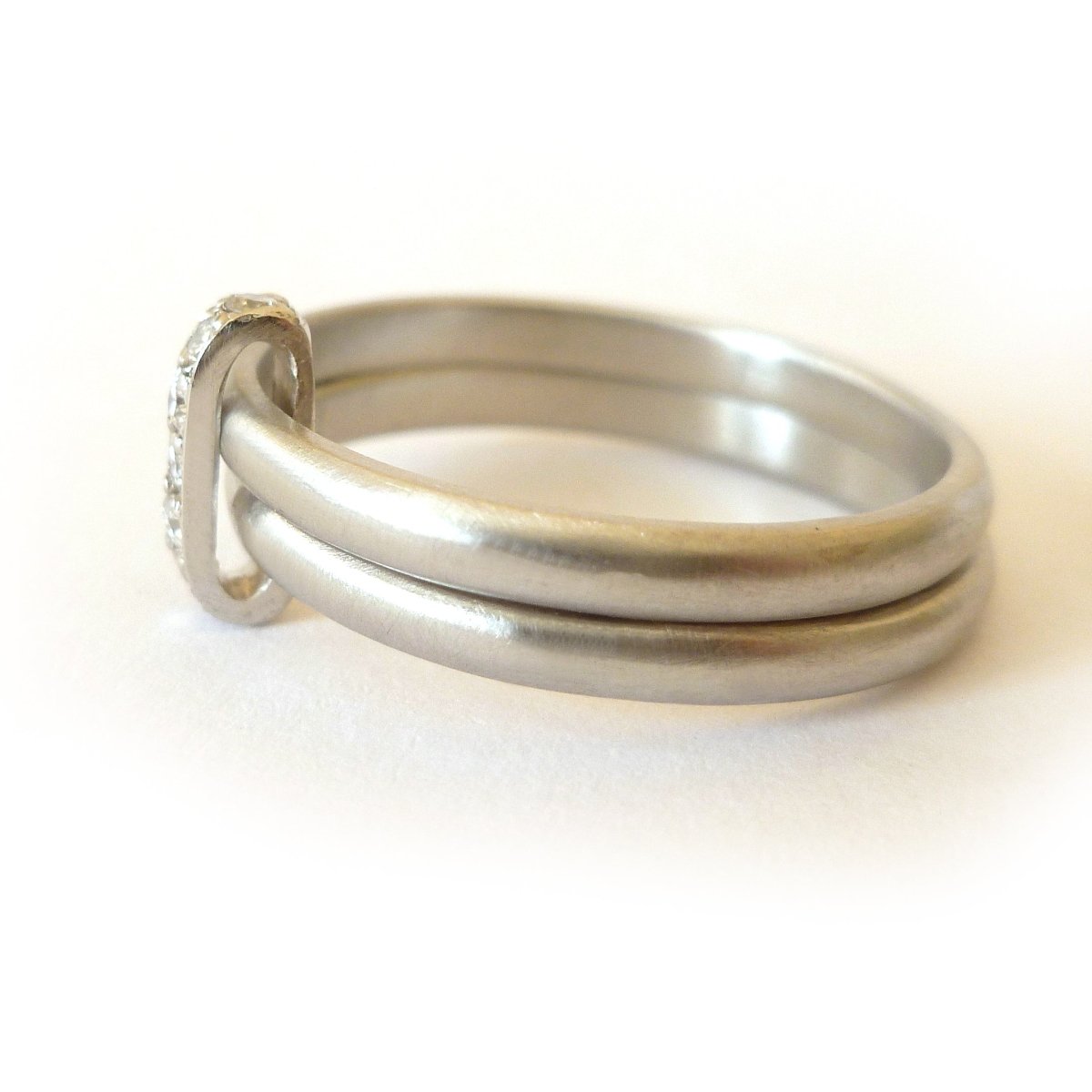 Contemporary two band platinum stacking ring with pave set diamonds. Multi band ring or interlocking ring, sometimes called double band ring too.