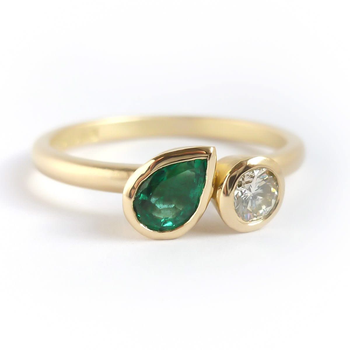 Pear shape emerald and diamond ring contemporary unique and modern.