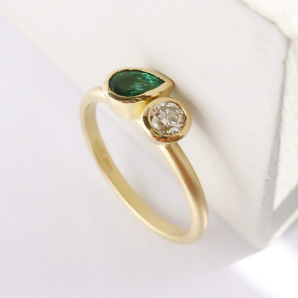 Pear shape emerald and diamond ring contemporary unique and modern.