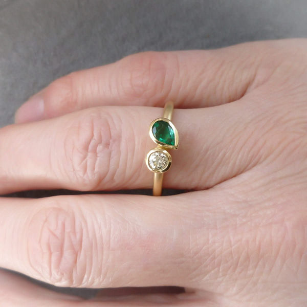 Pear shape emerald and diamond ring contemporary unique and modern.