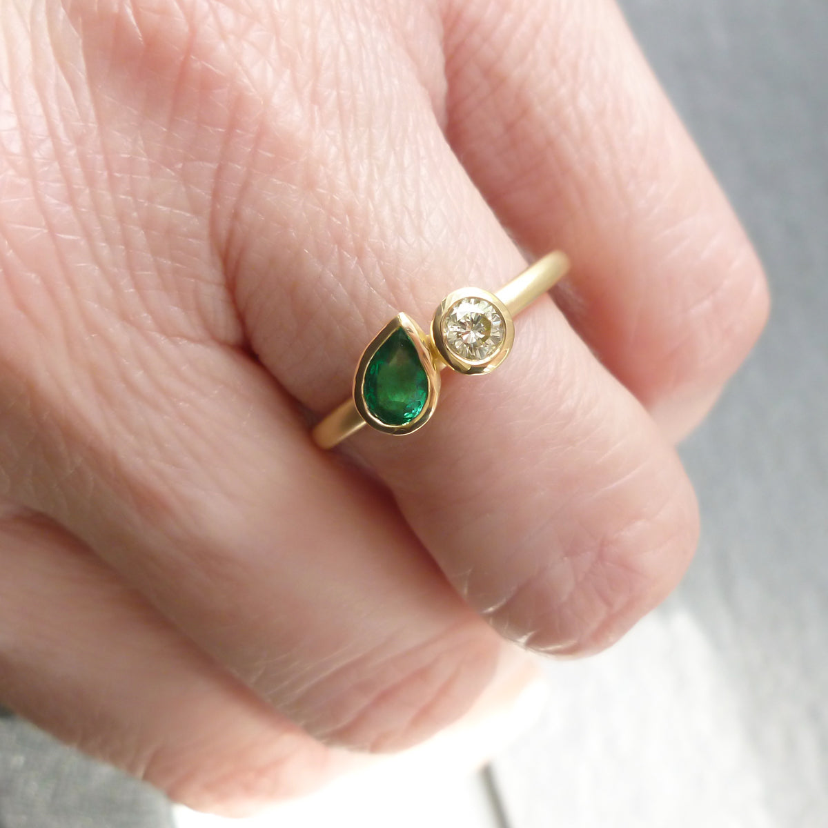 Pear shape emerald and diamond ring contemporary unique and modern.