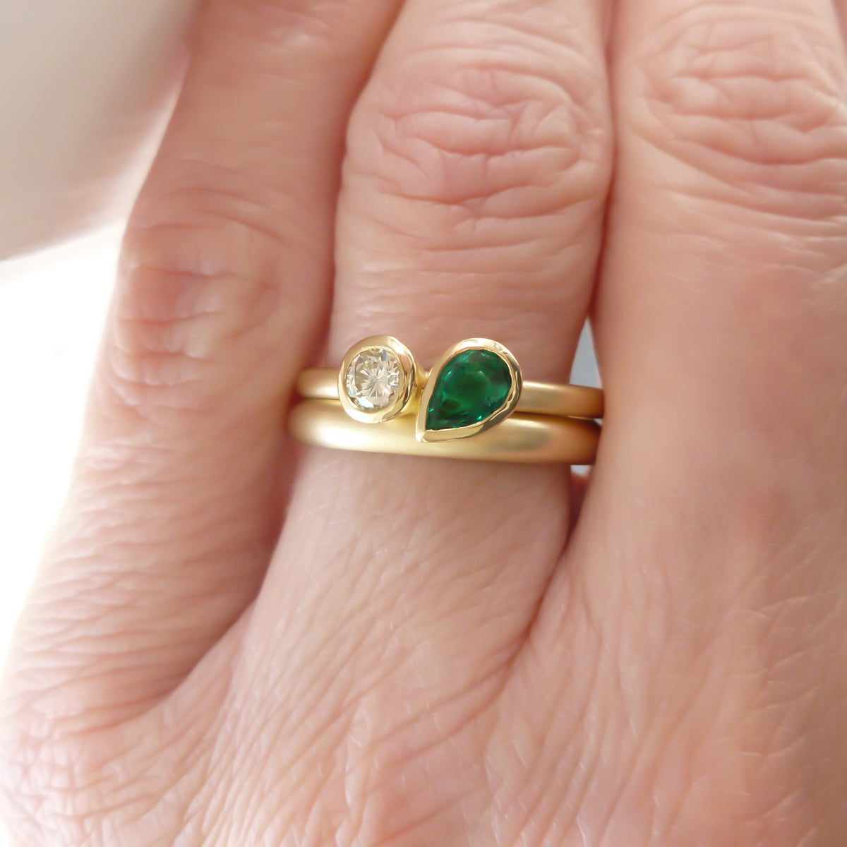 Pear shape emerald and diamond ring contemporary unique and modern.