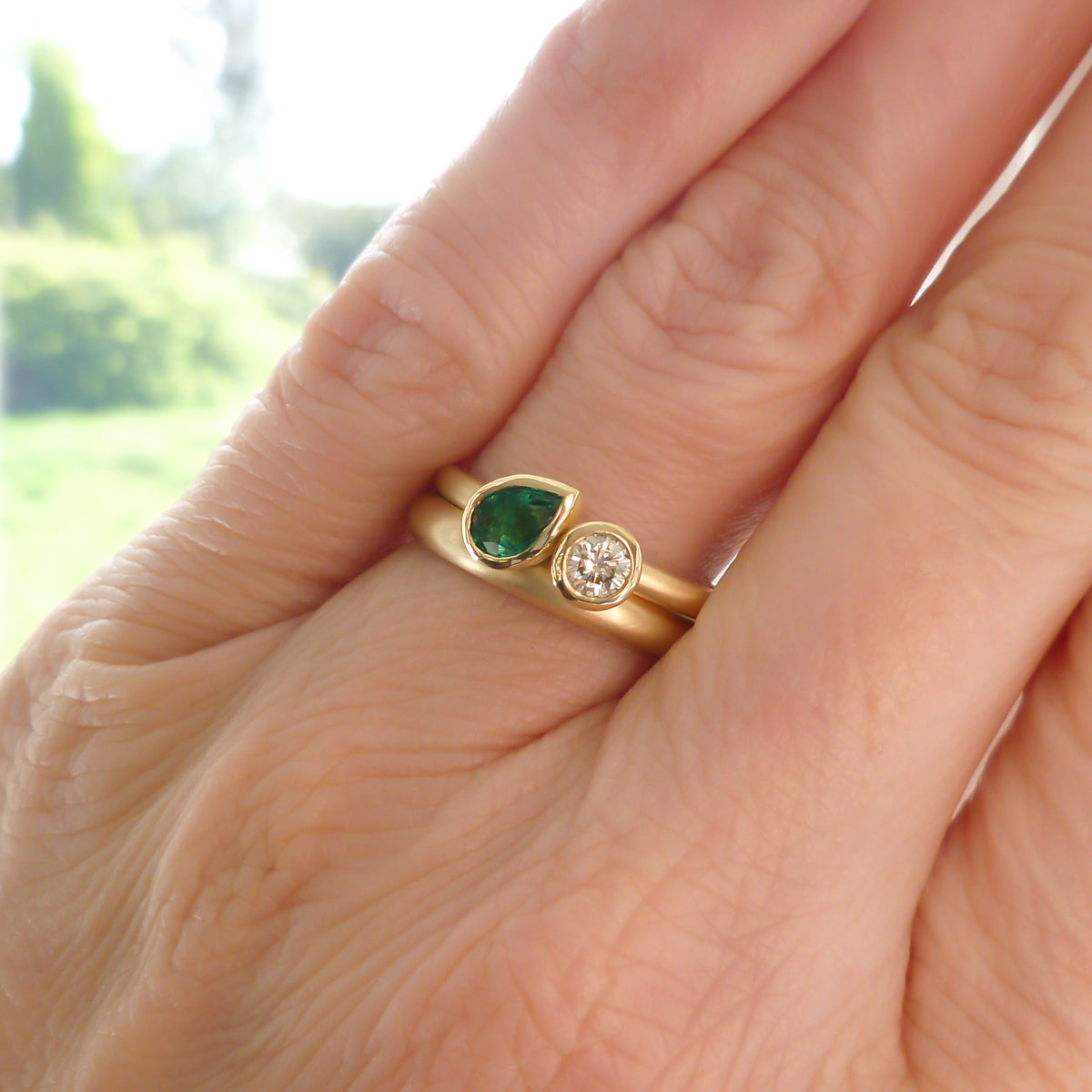 Pear shape emerald and diamond ring contemporary unique and modern.