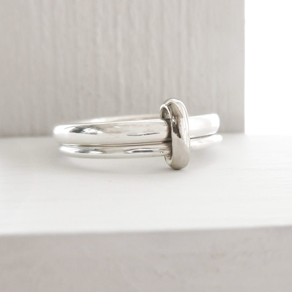 Detailed view of modern silver double band ring with subtle movement and contrasting 18ct gold loop.