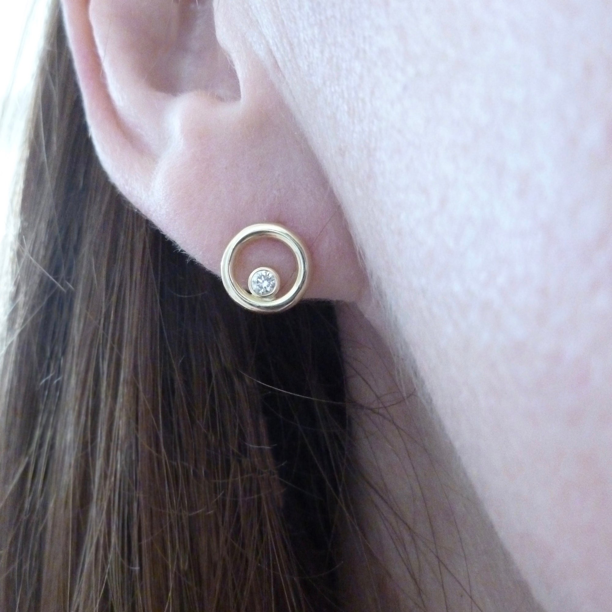 model wearing modern gold and diamond stud earrings