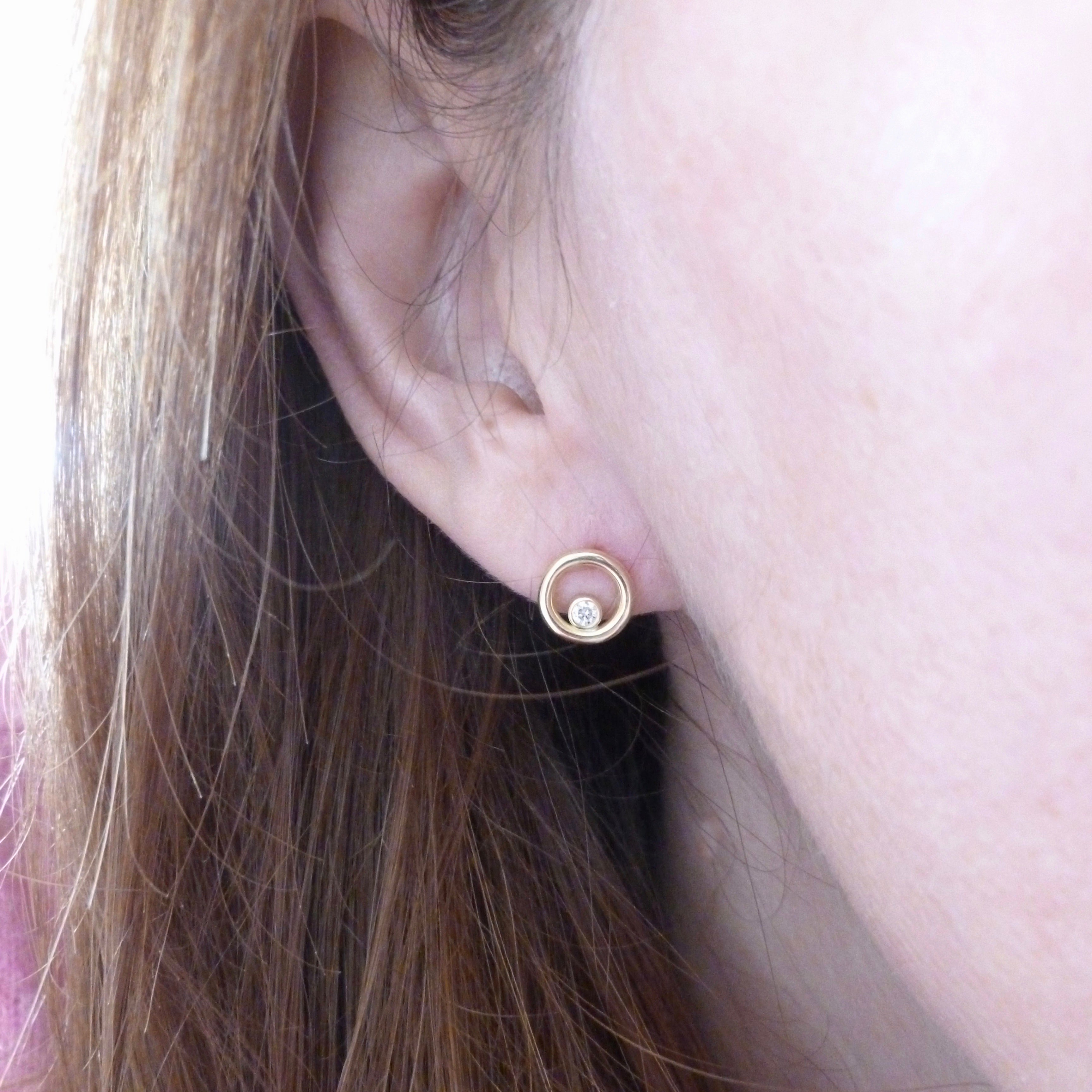 model wearing modern gold and diamond stud earrings