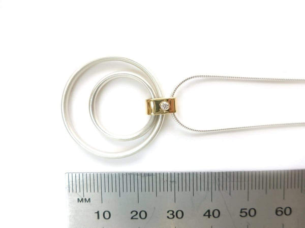 Close-up of a 2.2mm diamond flush-set in a polished 18ct gold loop with a soft matt silver finish.