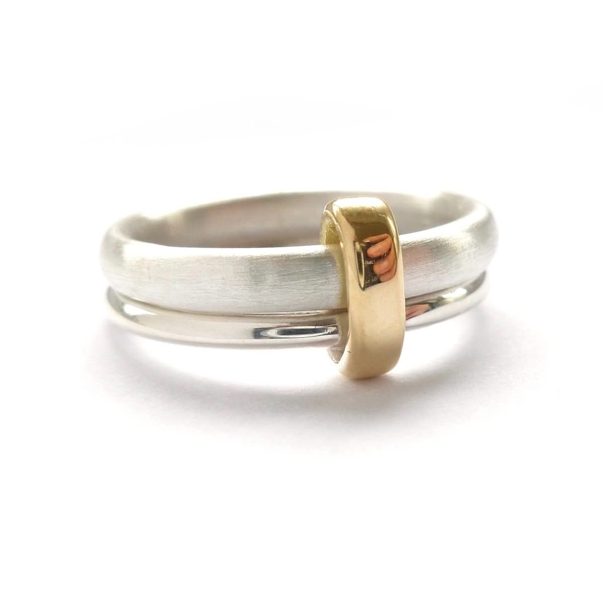 Handmade silver spinner ring with gold loop on a contemporary double‑band design, mixed‑metal luxury style