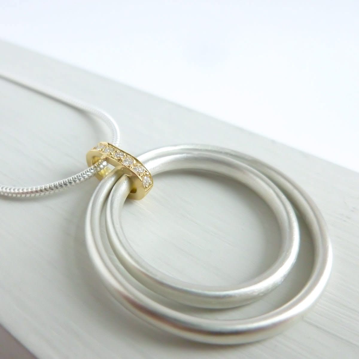 Side view of 7 diamonds set into a polished gold loop.